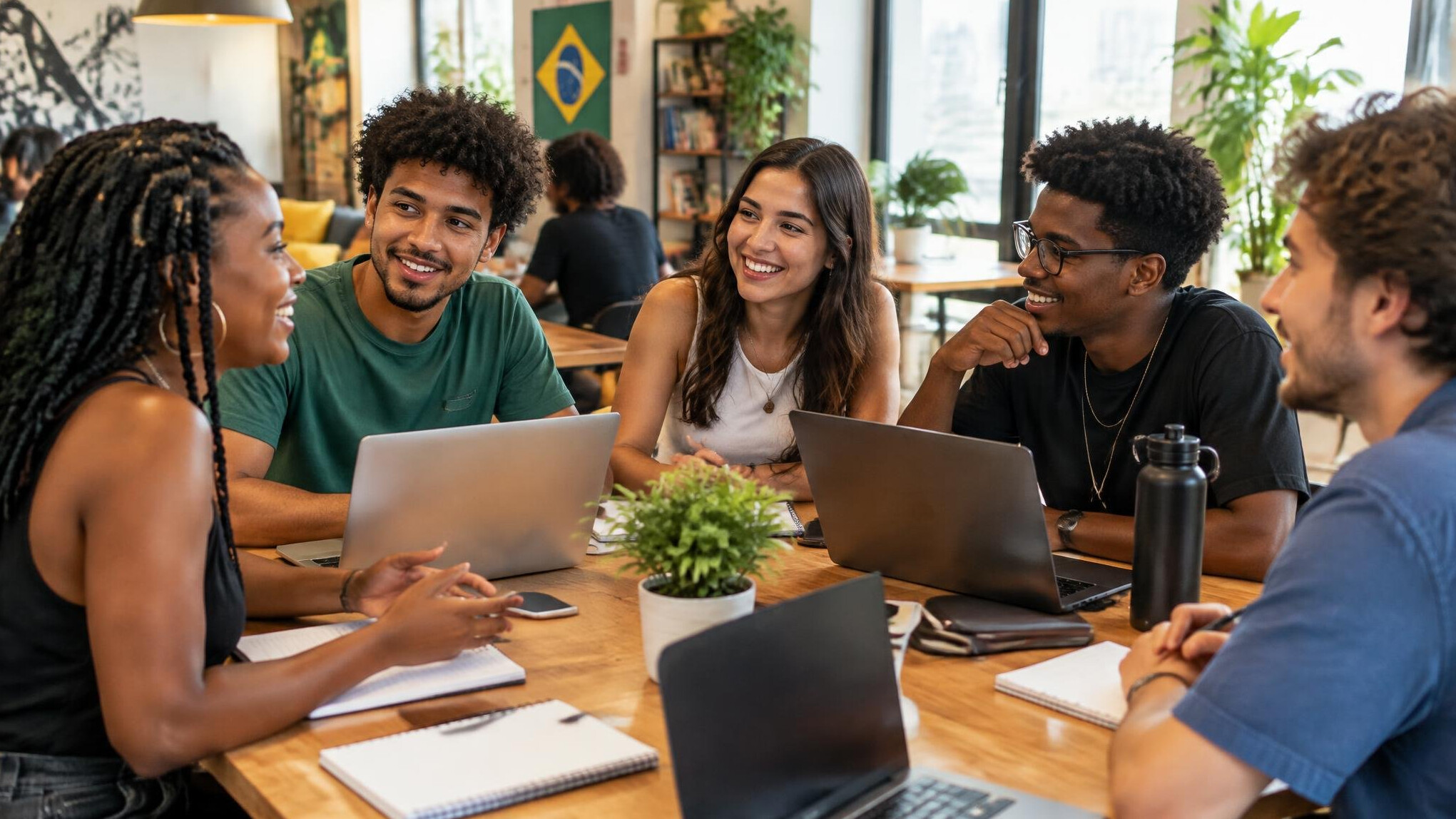 Group of young people studying together around a table with laptops