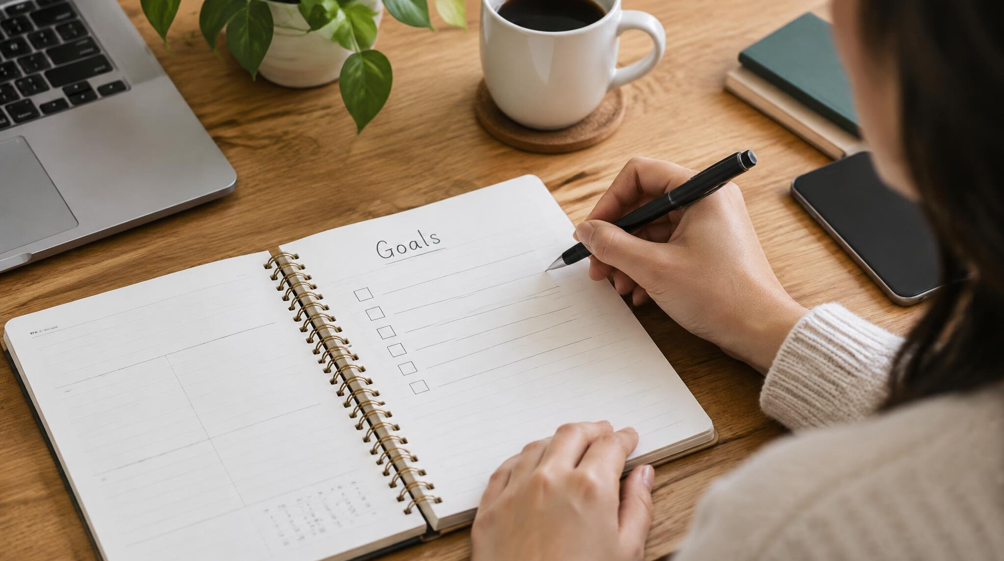 person writing goals in notebook